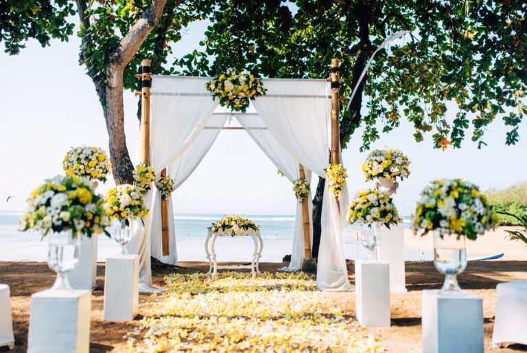 Allestimento romantico per matrimonio in spiaggia con arco floreale vista mare