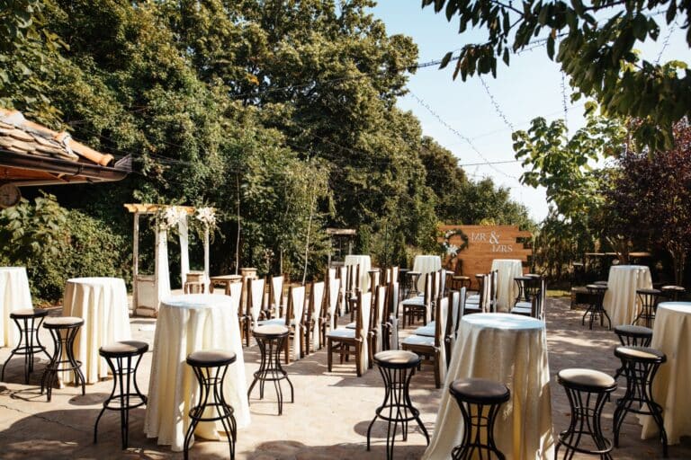 Sedute e tavoli alti allestiti in giardino per ricevimento o festa privata