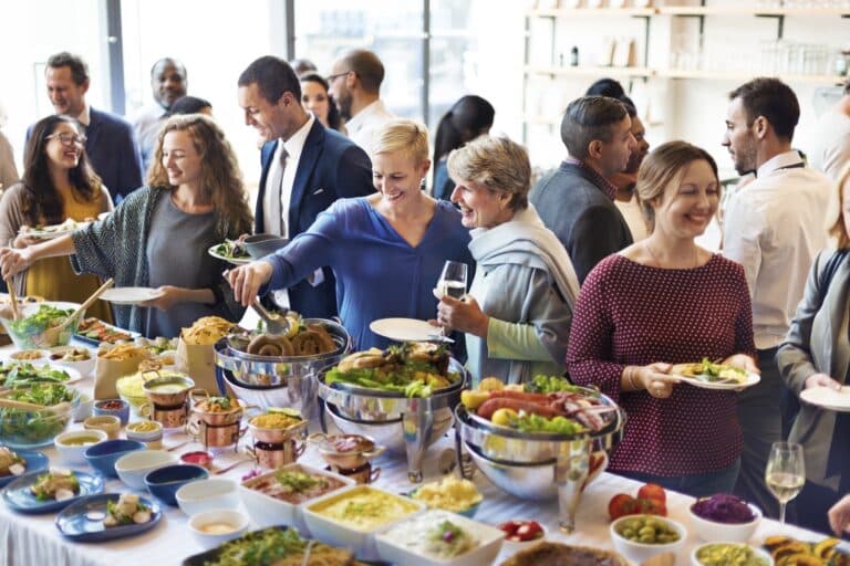 Partecipanti a un evento aziendale durante un buffet e momento di networking