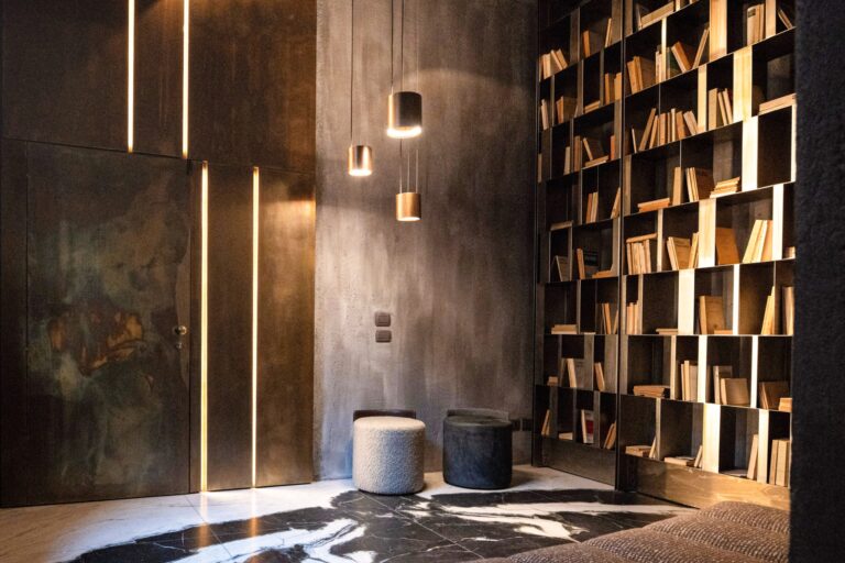 Ambiente elegante con libreria, luci calde e sedute per incontri professionali