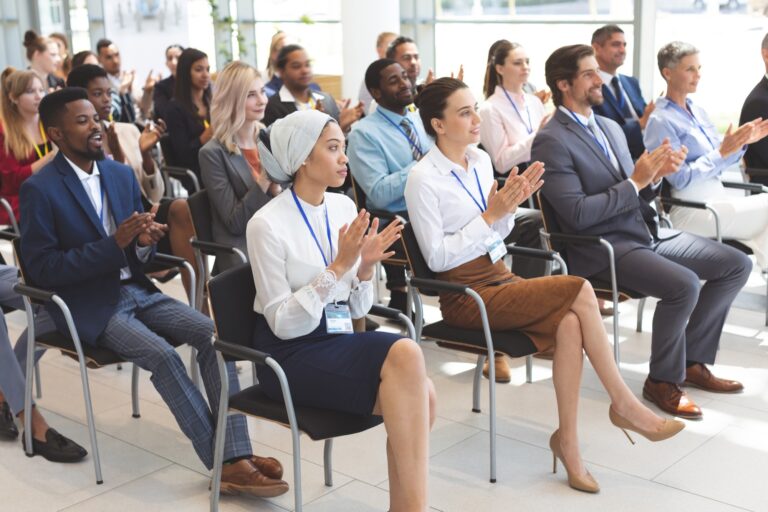 Partecipanti a un kick-off aziendale applaudono durante un evento corporate