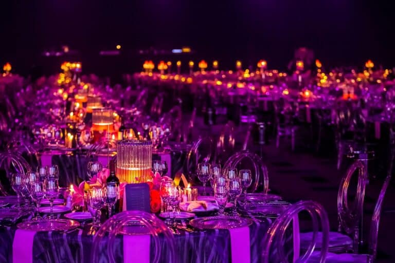 Sala allestita per un gala di beneficenza con tavoli eleganti e luci soffuse